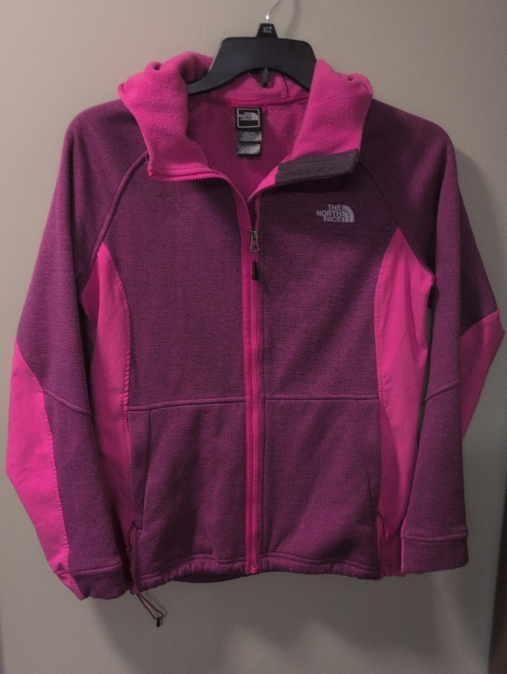 The North Face pink fleece zip-up hoodie featuring a contrasting pink zipper.